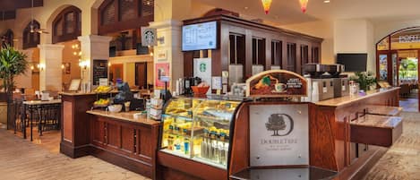 Vestíbulo de DoubleTree by Hilton Ontario Airport con una Starbucks, una presentación de alimentos y un área de descanso.