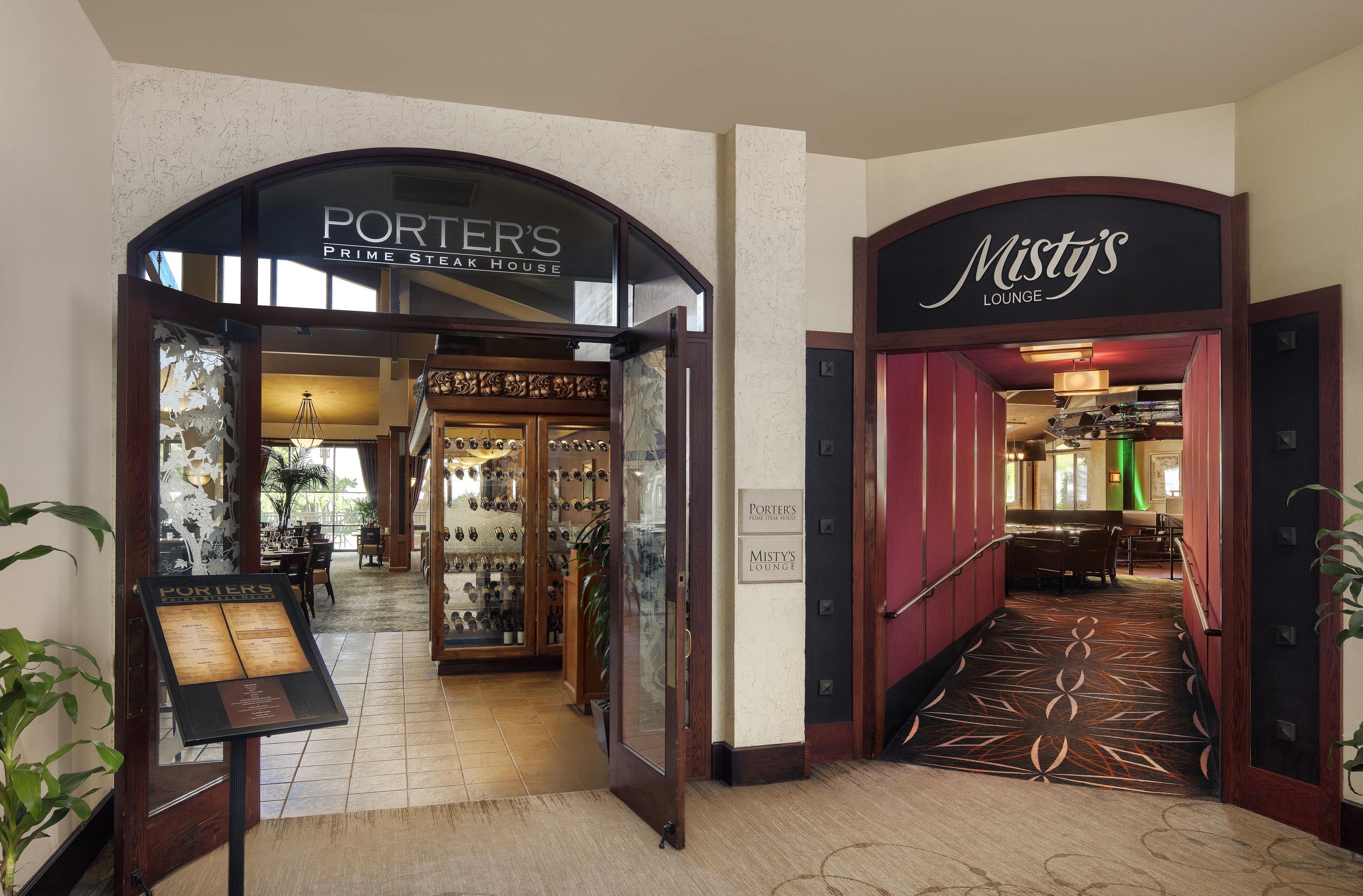 L'entrée du restaurant Porter's Prime Steak House et du bar Misty's Lounge se distingue par une porte en bois et un panneau indicateur.