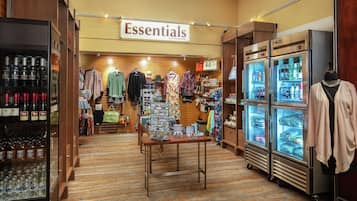 A hotel store with shelves of alcohol, clothing racks, and a display of jewelry.