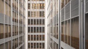 Un edificio moderno con un atrio central, varios pisos y ventanas amplias.
