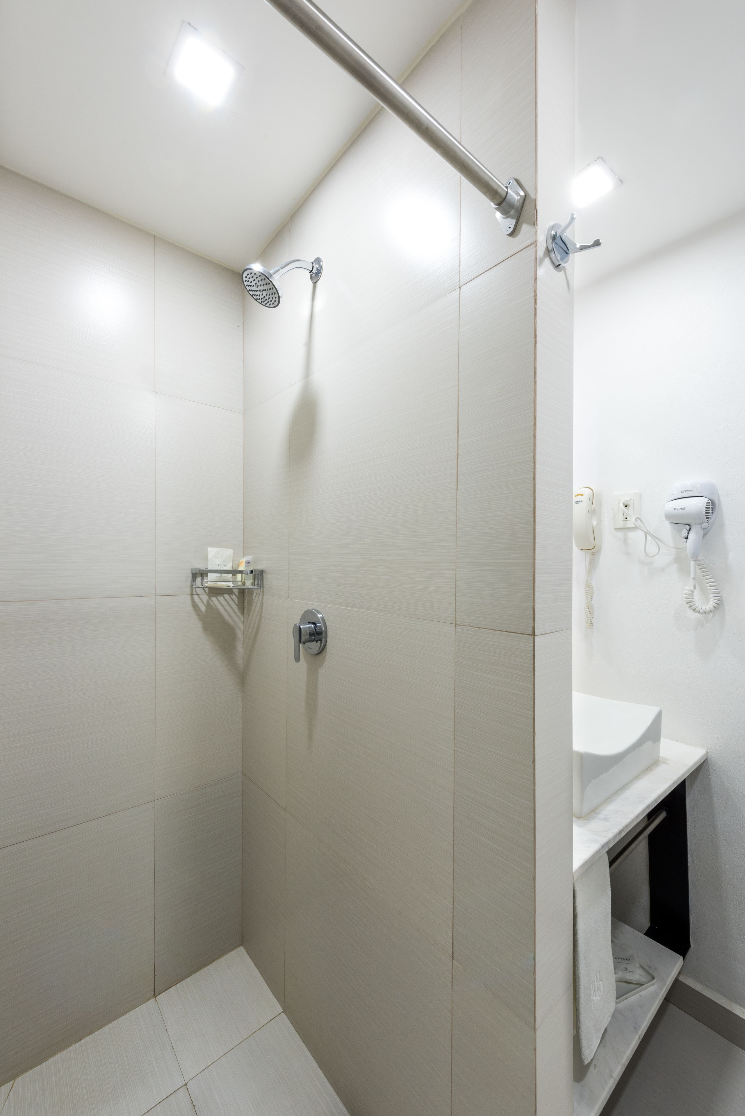 A modern bathroom with a shower, a toilet, and a sink.