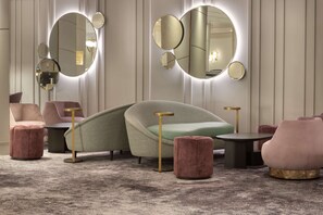 Relax in style with a curved sofa, round mirrors, and plush ottomans.