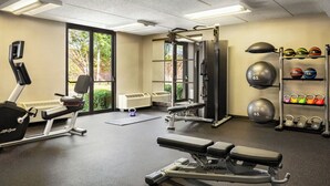 Ein Fitnessstudio mit Cardiogeräten, Krafttrainingsgeräten und Kurzhanteln.