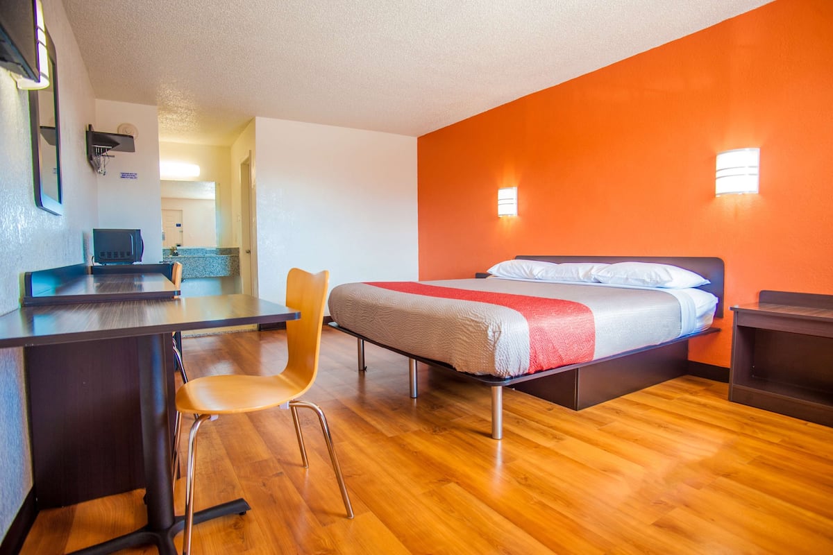 Une chambre d’hôtel avec un lit, un bureau et une chaise.