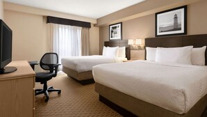 A hotel room with two beds, a desk with a computer, and a TV. - Travelodge Suites by Wyndham Moncton (Moncton)
