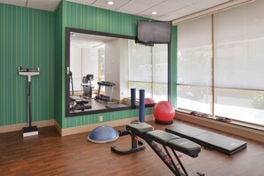 A gym with exercise equipment, a mirror, and a television. - Holiday Inn Express & Suites Buffalo Downtown - Medical CTR by IHG (Buffalo)