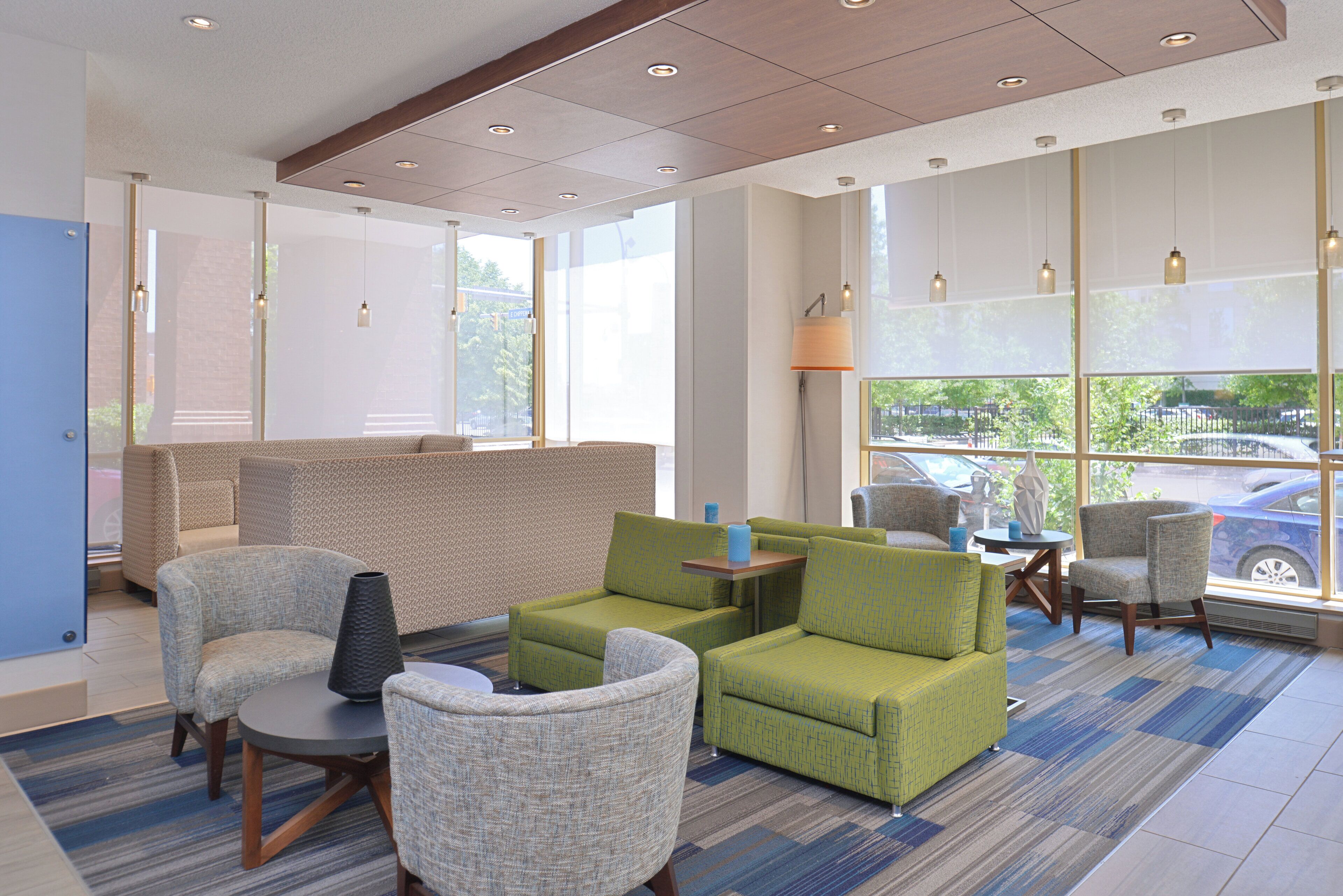 A hotel lobby with seating areas, a coffee table, and a lamp.