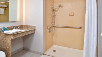 A bathroom with a shower, toilet, and sink.
