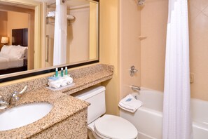 A bathroom with a granite countertop sink, a toilet, and a bathtub. - Holiday Inn Express & Suites Buffalo Downtown - Medical CTR by IHG (Buffalo)