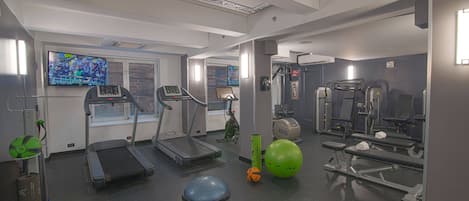 A gym with treadmills, exercise balls, and weight machines.