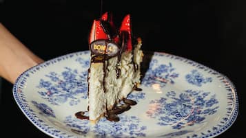 A slice of cake on a plate with a decorative topping and a chocolate drizzle.