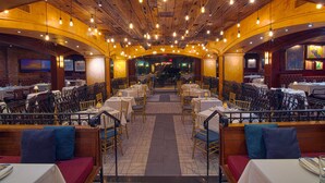 A restaurant with a central aisle, tables, and booths.