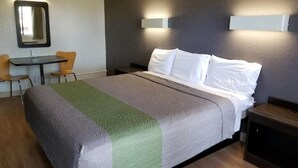 A hotel room with a bed, a small table, two chairs, and a mirror. - The Inn at Market Square (San Antonio)