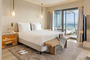 A modern hotel room with a large bed, bedside tables, a bench, and a balcony with a view. - EVOLUTION Cascais-Estoril Hotel (Cascais)