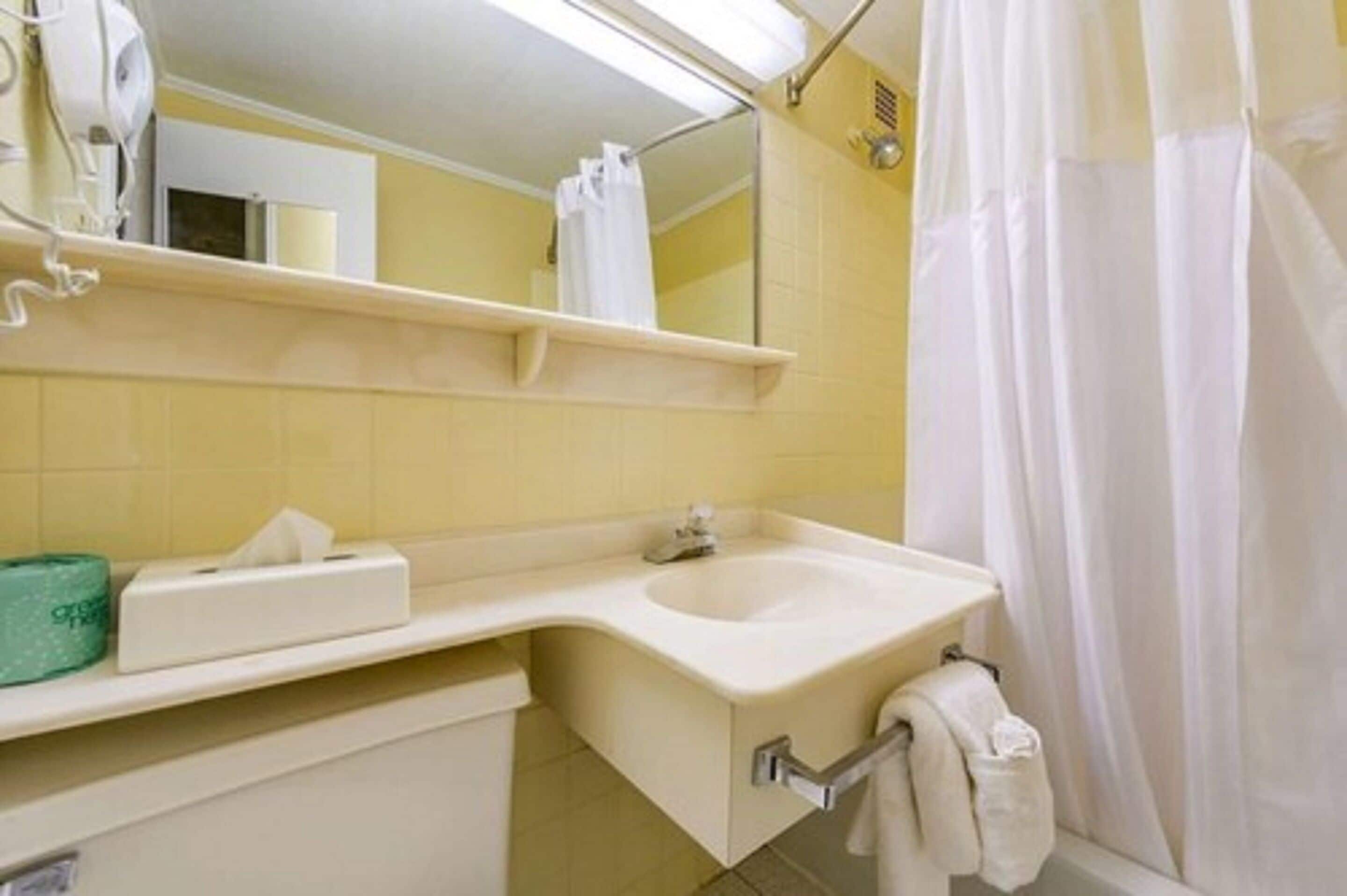 A bathroom with a sink, mirror, and towel rack.