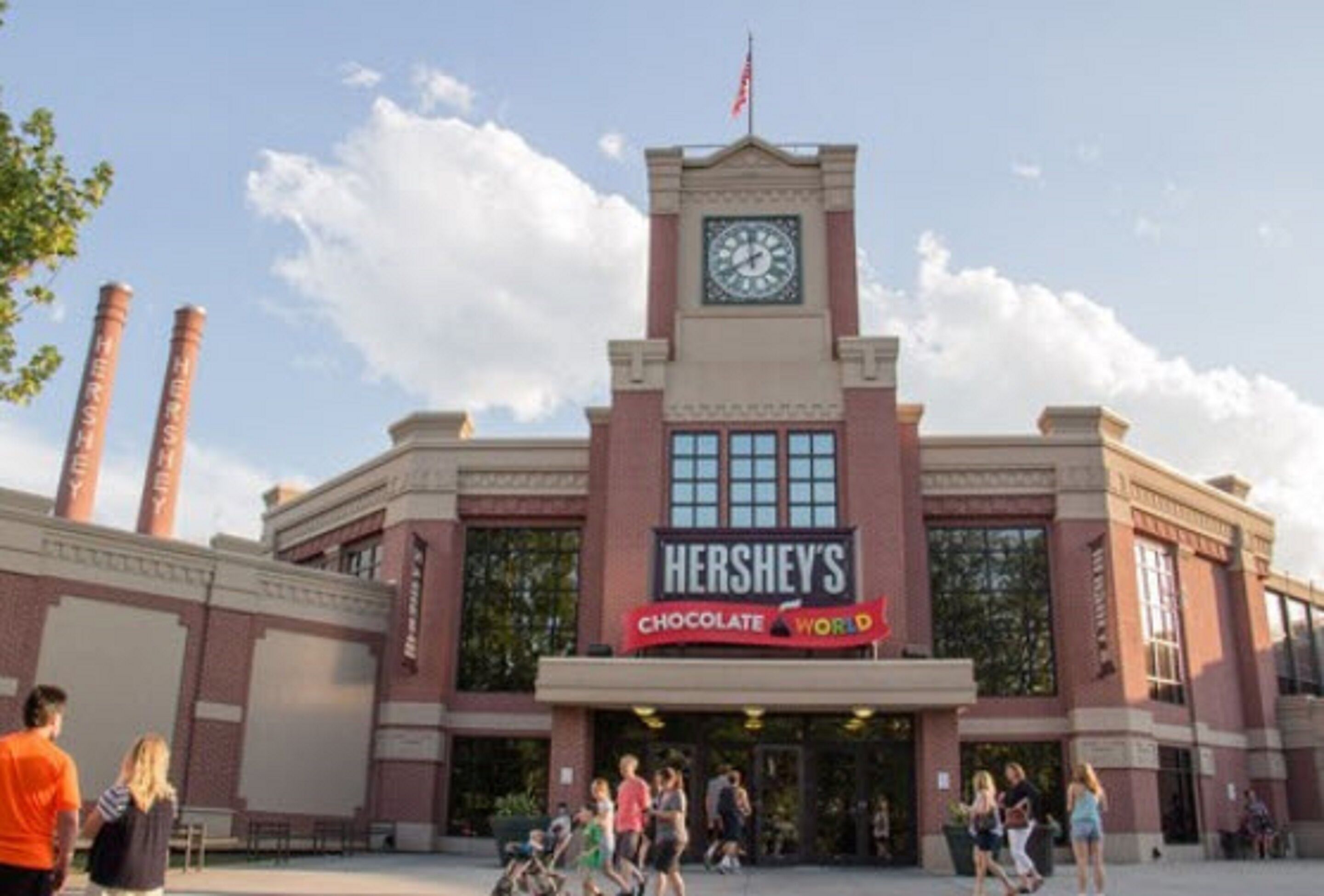 Ein Gebäude von Hershey's Chocolate World mit einem Glockenturm, einer Ziegelkünstlichkeit und großen Fenstern.