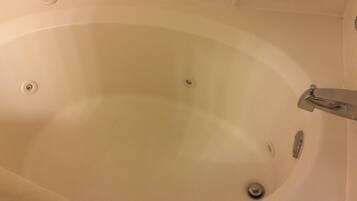 Una bañera blanca con grifo y desagüe.