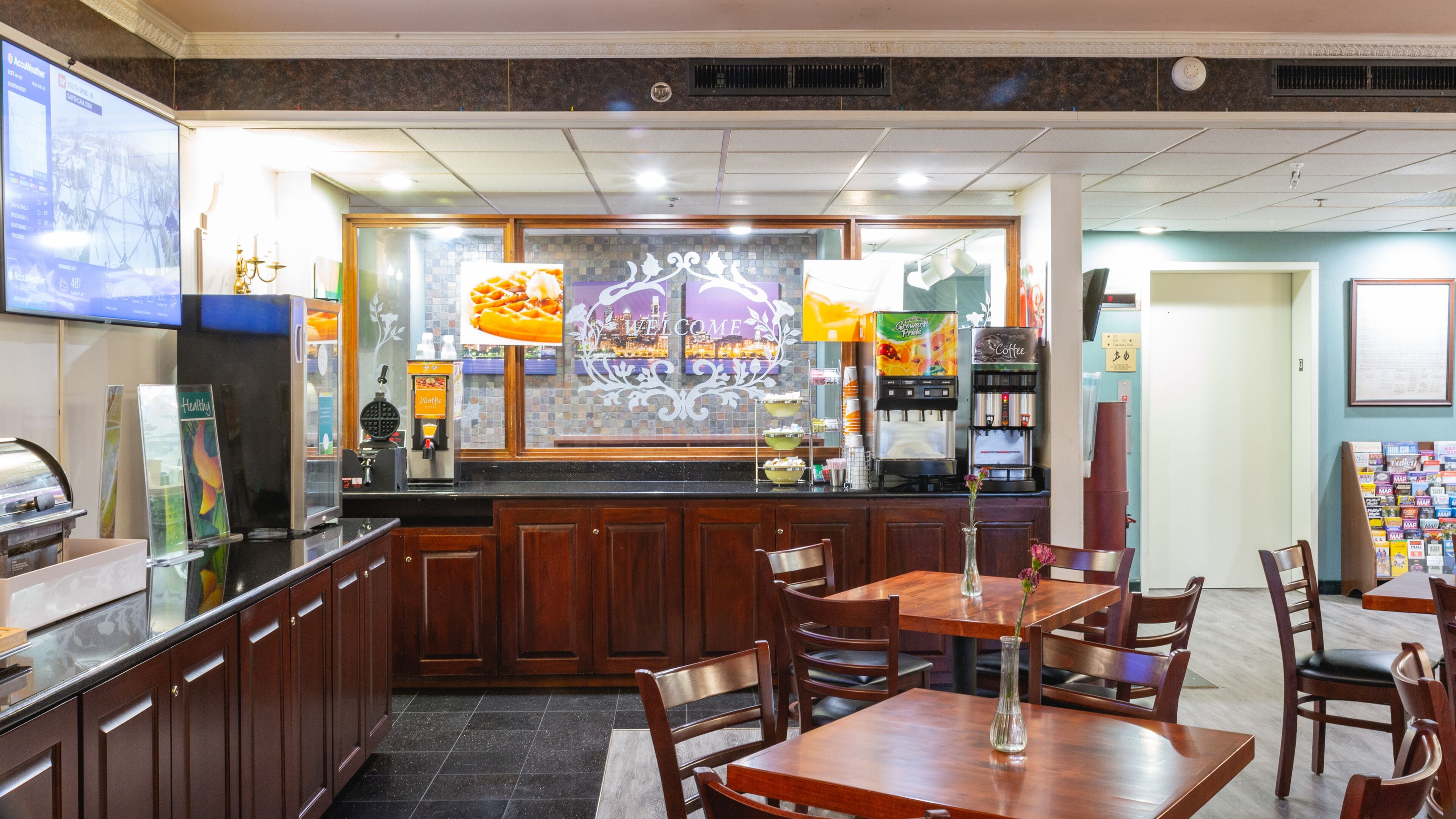A restaurant interior with a counter, seating area, and a menu board.