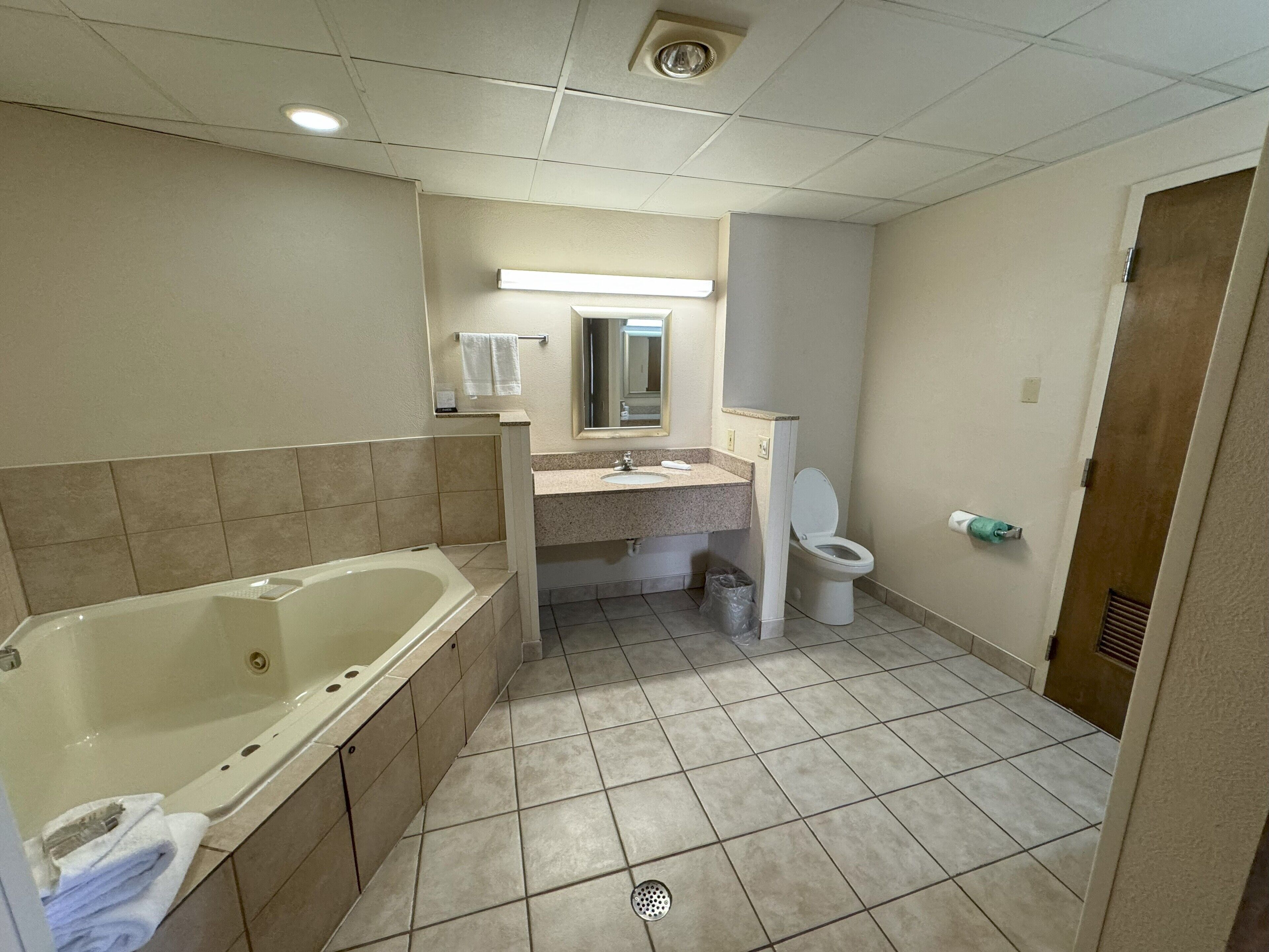 A bathroom with a bathtub, sink, toilet, and a mirror.