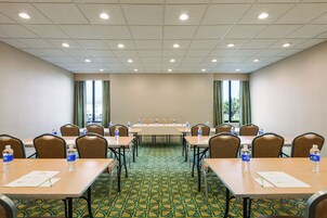 Ein Konferenzraum mit Tischen, Stühlen und Wasserflaschen.
