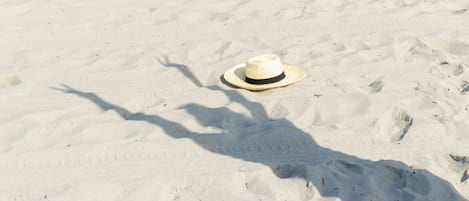 A straw hat on a sandy beach.