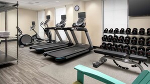 A gym with treadmills, a stationary bike, and a rack of dumbbells. - Home2 Suites by Hilton Atlanta Midtown (Atlanta)