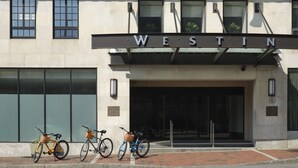 El exterior del hotel Westin, con una entrada destacada y dos bicicletas estacionadas al frente.
