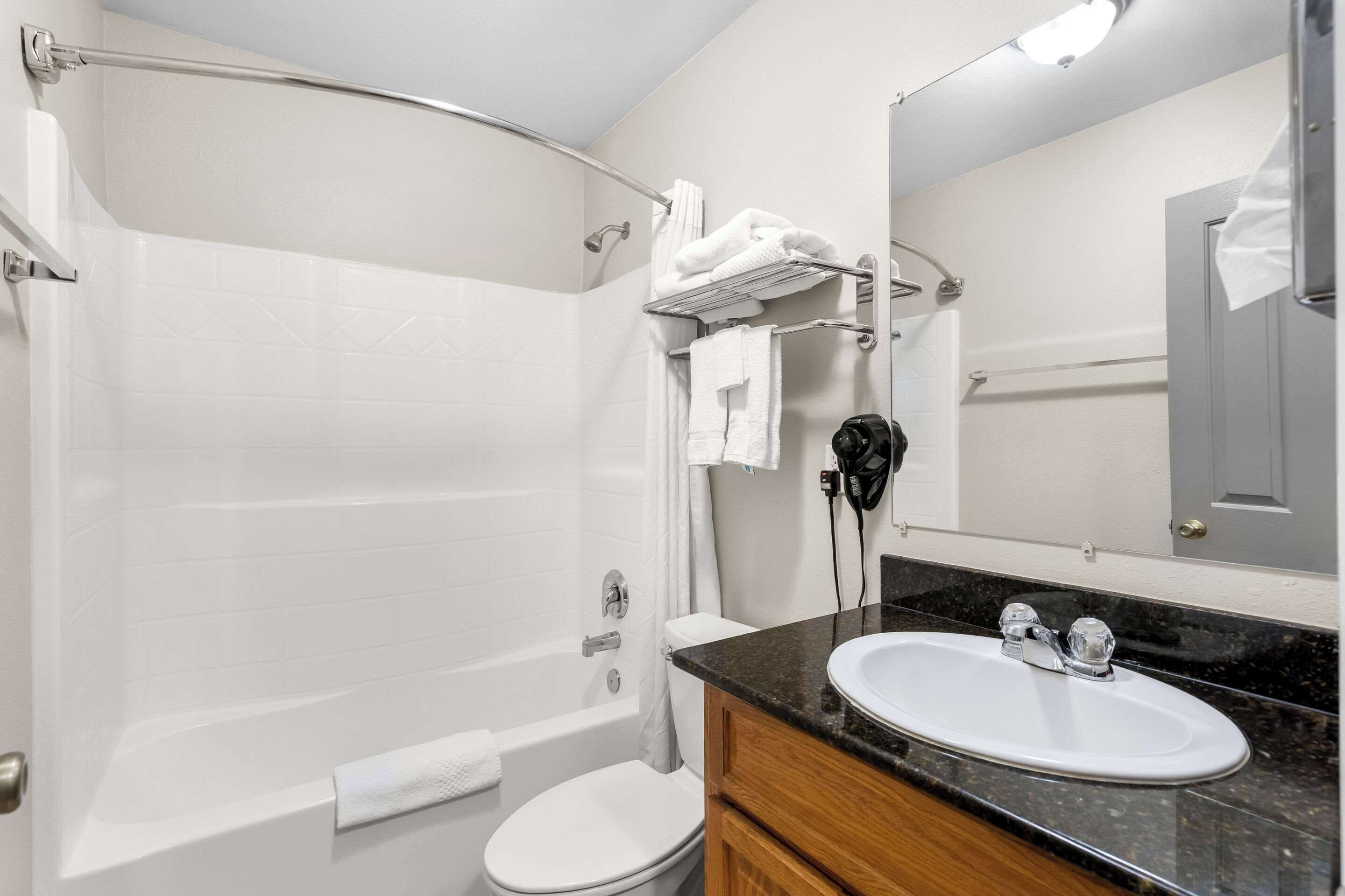 A bathroom with a bathtub, toilet, sink, and a towel rack.