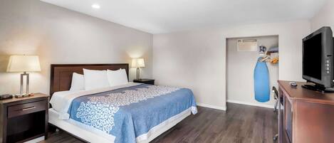 A hotel room with a bed, nightstands, a television, and a blue exercise ball against the wall.