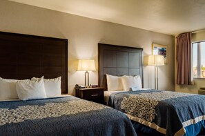 A hotel room with two beds, each with a headboard, bedside tables with lamps, and a window with curtains. - Econo Lodge Panguitch near Bryce Canyon (Panguitch)