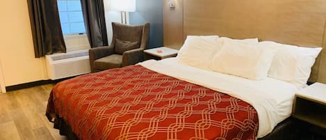 Une chambre d’hôtel équipée d’un lit, d’une chaise, d’une table de chevet, d’une lampe et d’un appareil de climatisation.