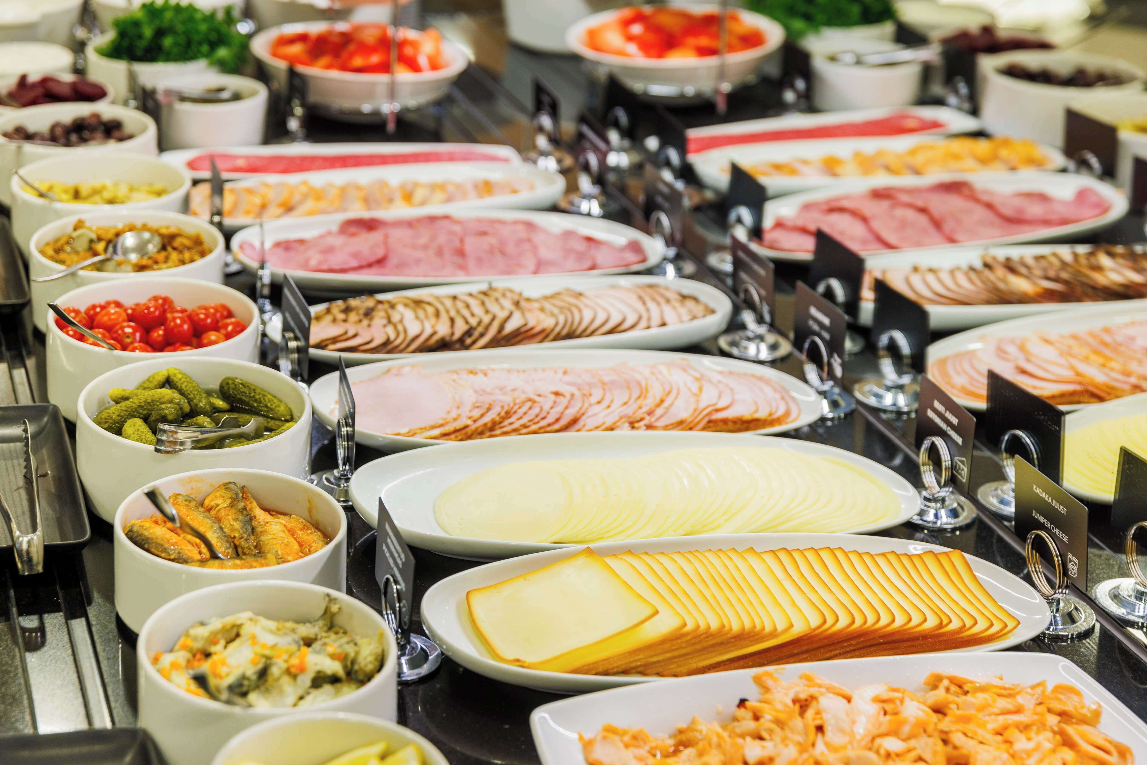 A buffet with various food options including meats, cheeses, and vegetables.
