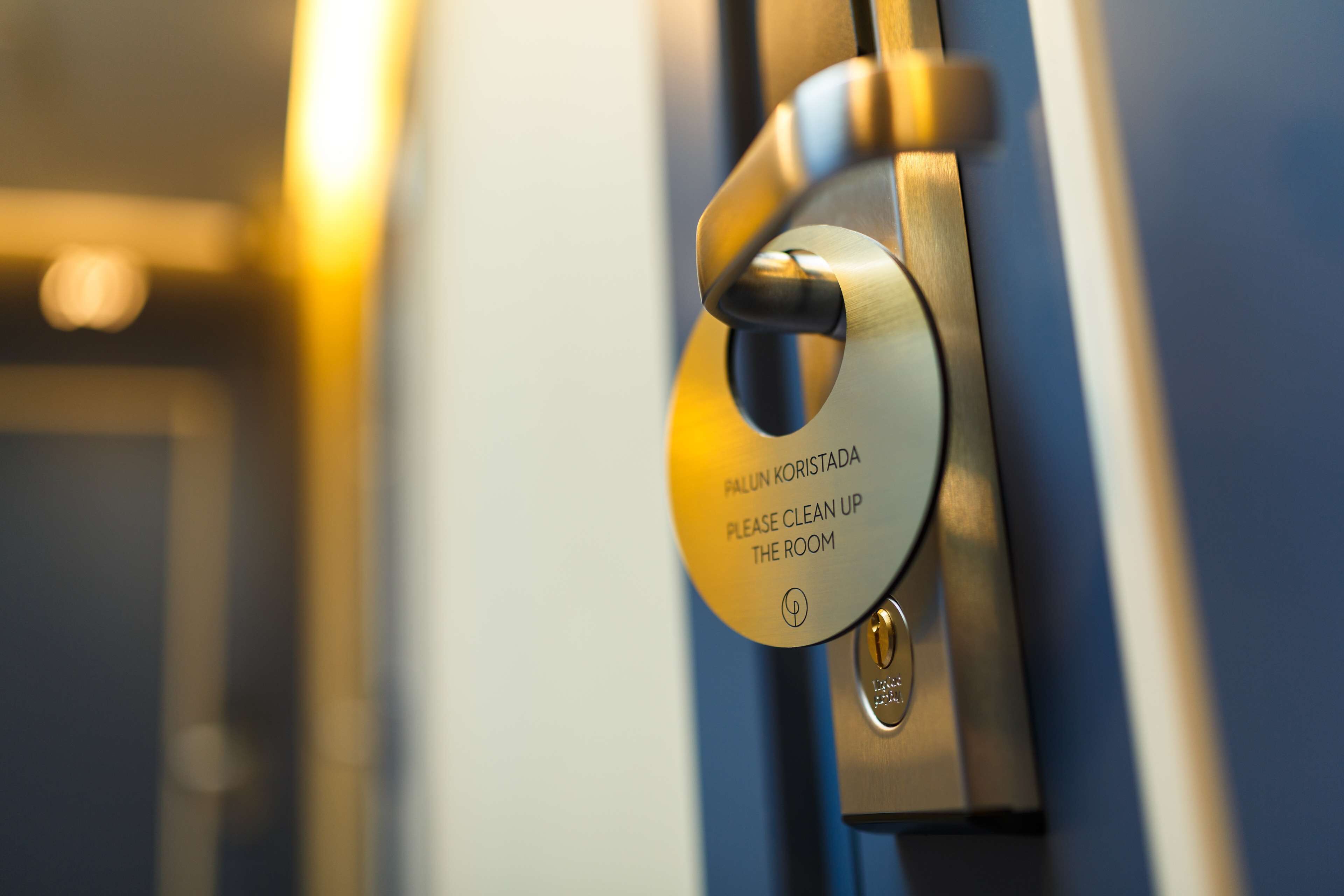 A door with a sign that reads "FALUN KORISTADA PLEASE CLEAN UP THE ROOM."