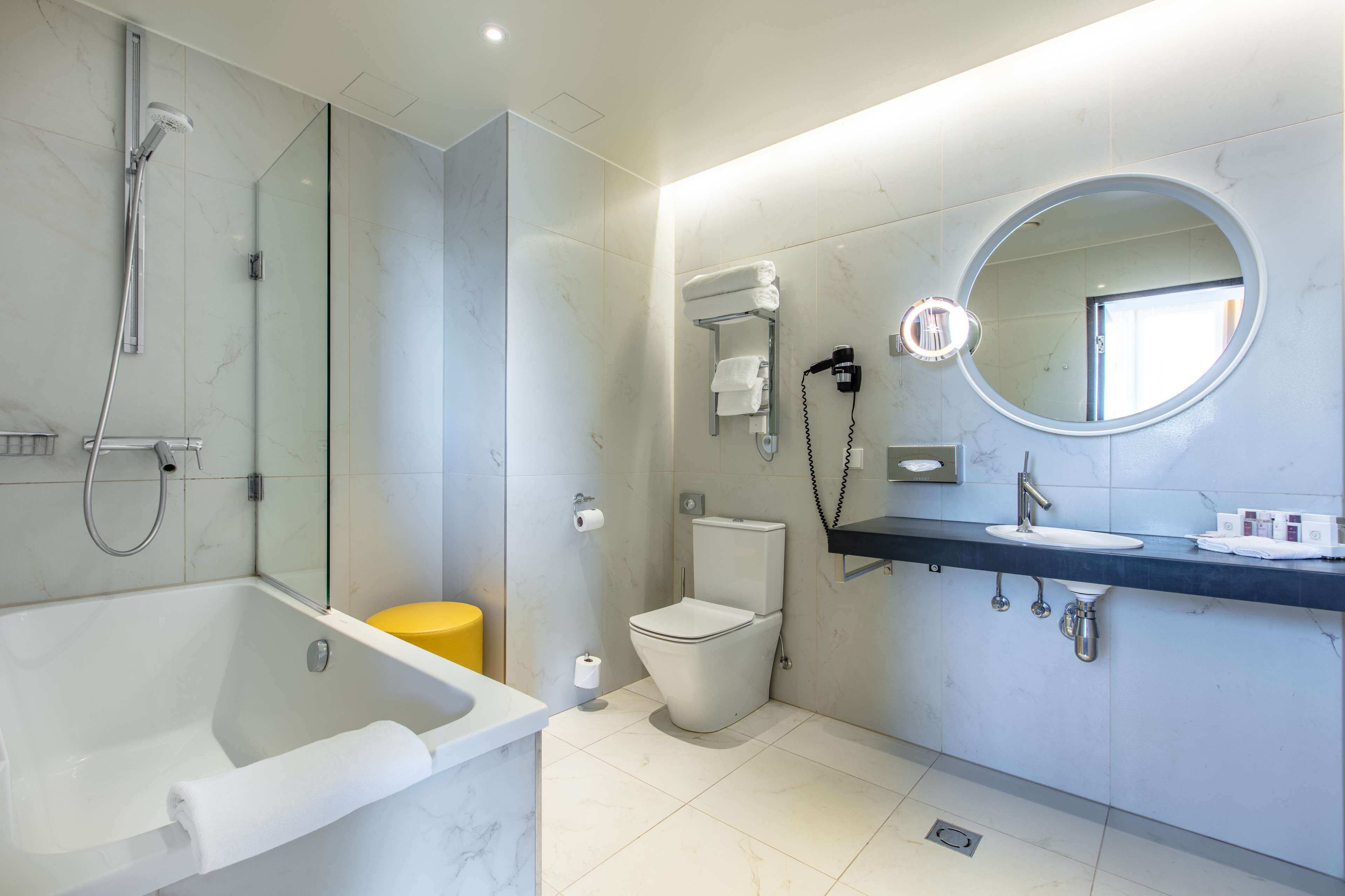Une salle de bain moderne équipée d’une baignoire, de toilettes et d’un espace douche.