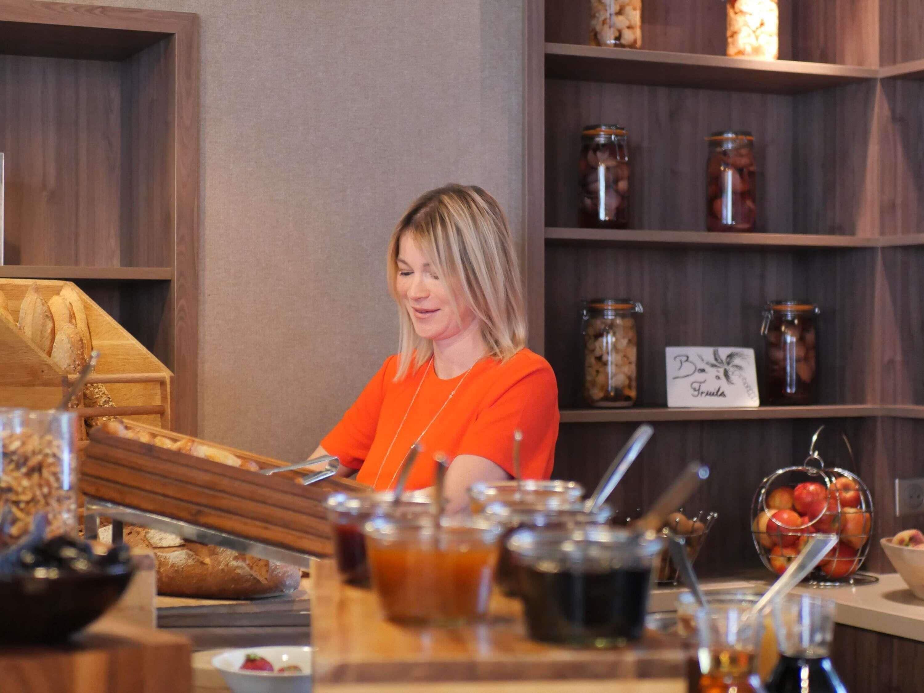 A buffet area with various food items and a person serving.