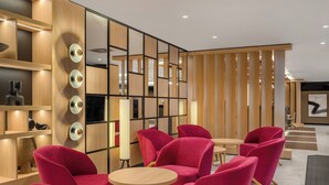 Un interior moderno con paneles de madera, mesas redondas y sillas rojas vibrantes.