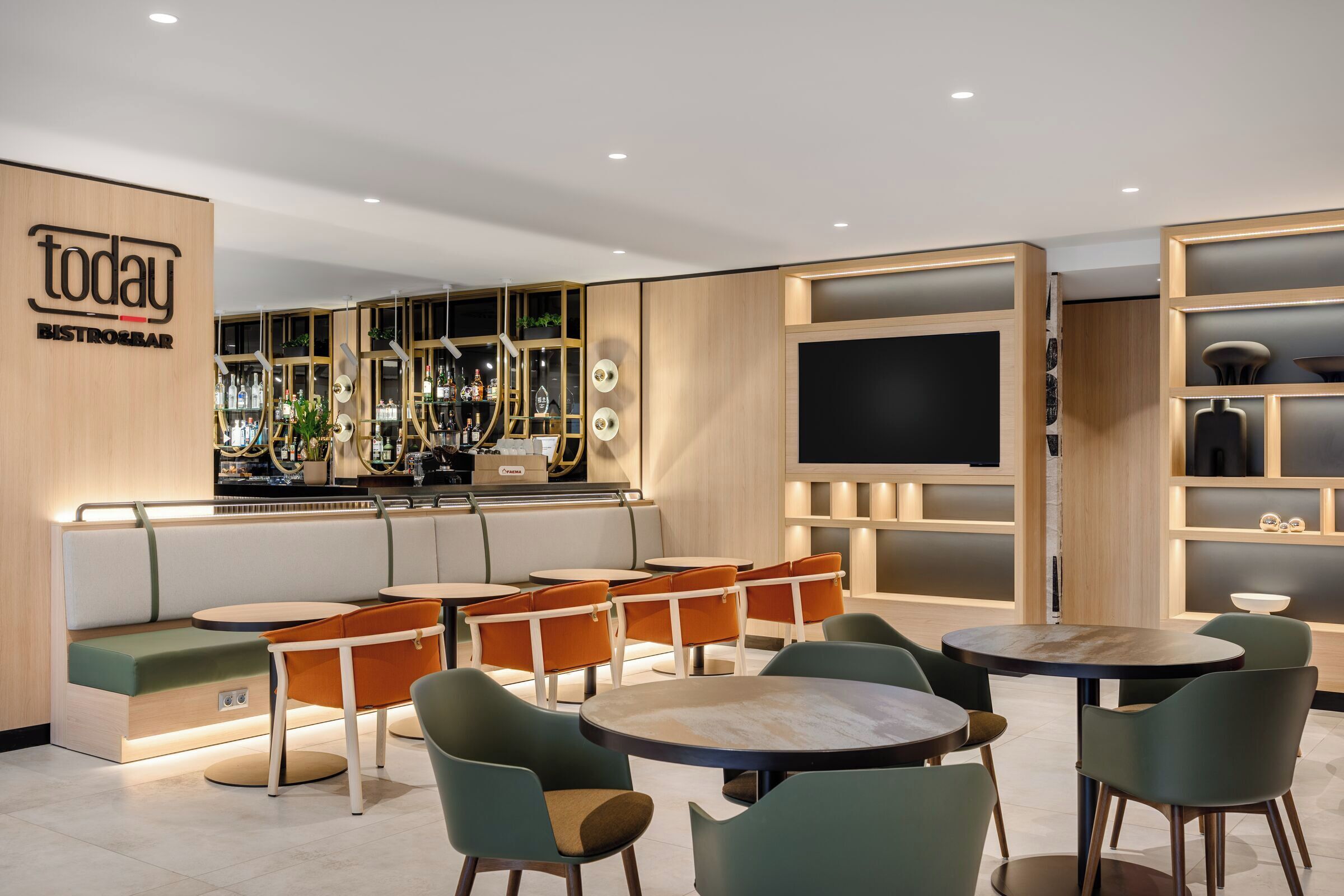 A modern bar area with seating, a TV screen, and a bar counter.