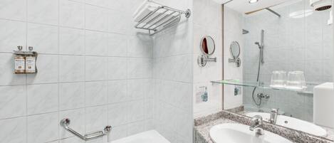 Un bagno moderno con vasca, un mobile lavabo, box doccia in vetro e uno specchio.