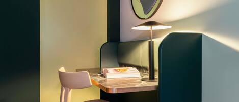 A corner desk with a chair, a lamp, and a book.