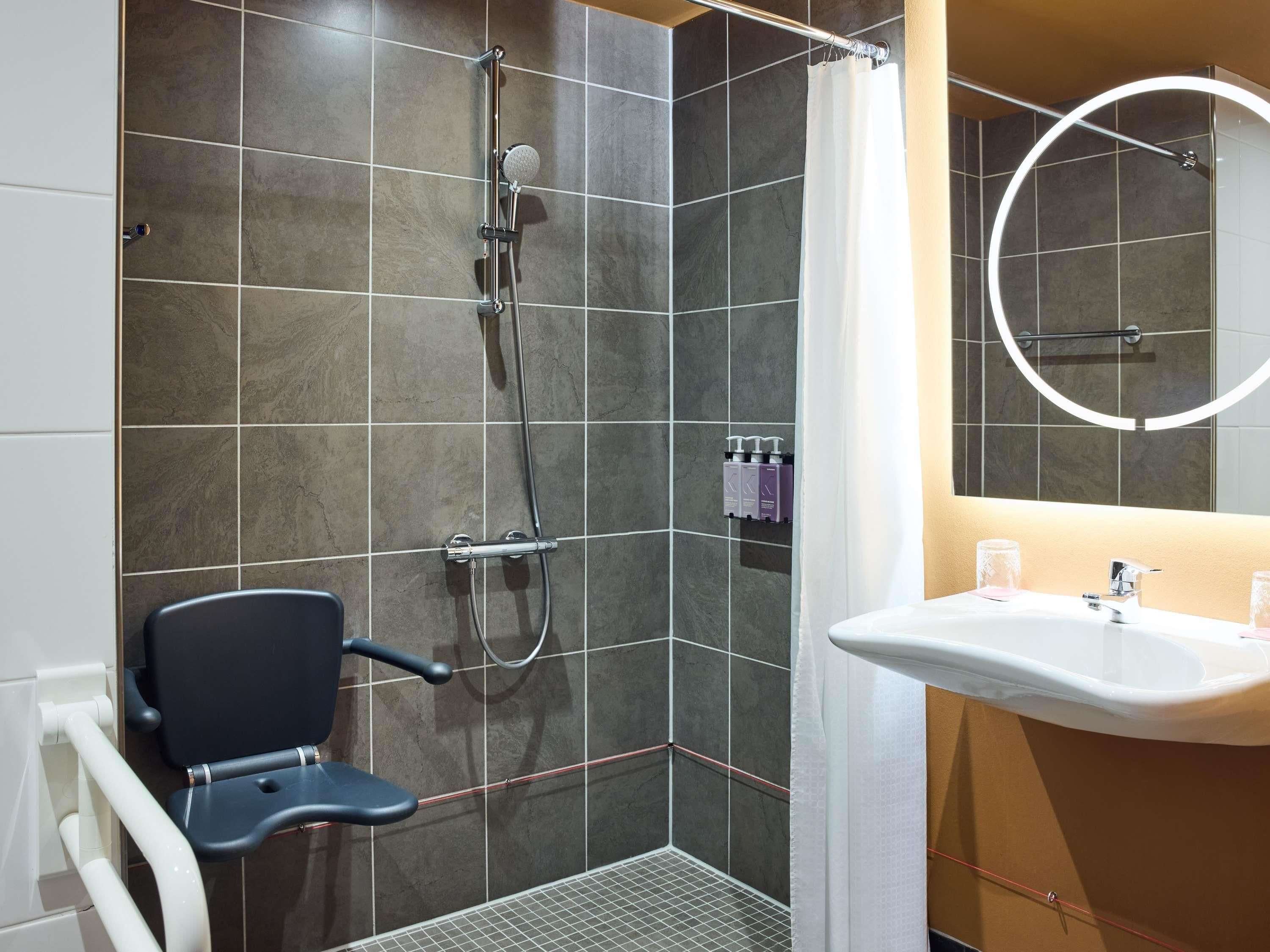 A modern bathroom with a shower, a toilet, and a sink.
