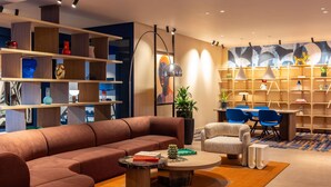 A modern living room with a sectional sofa, a coffee table, and a dining area with chairs and a table.
