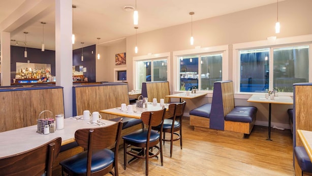 A restaurant with booths, tables, and a bar area. - Sandman Inn McBride (McBride)