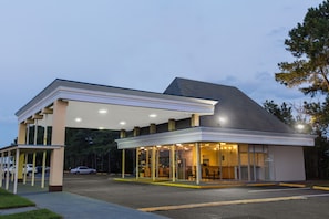 A gas station with a covered area and a building with a sloped roof. - Garden Inn (Fredericksburg)