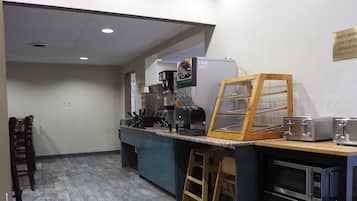 A kitchenette with a coffee machine, toaster, and microwave.