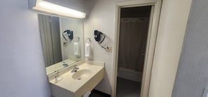 A bathroom with a sink, mirror, and hairdryer.