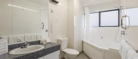A modern bathroom with a sink, toilet, and bathtub.