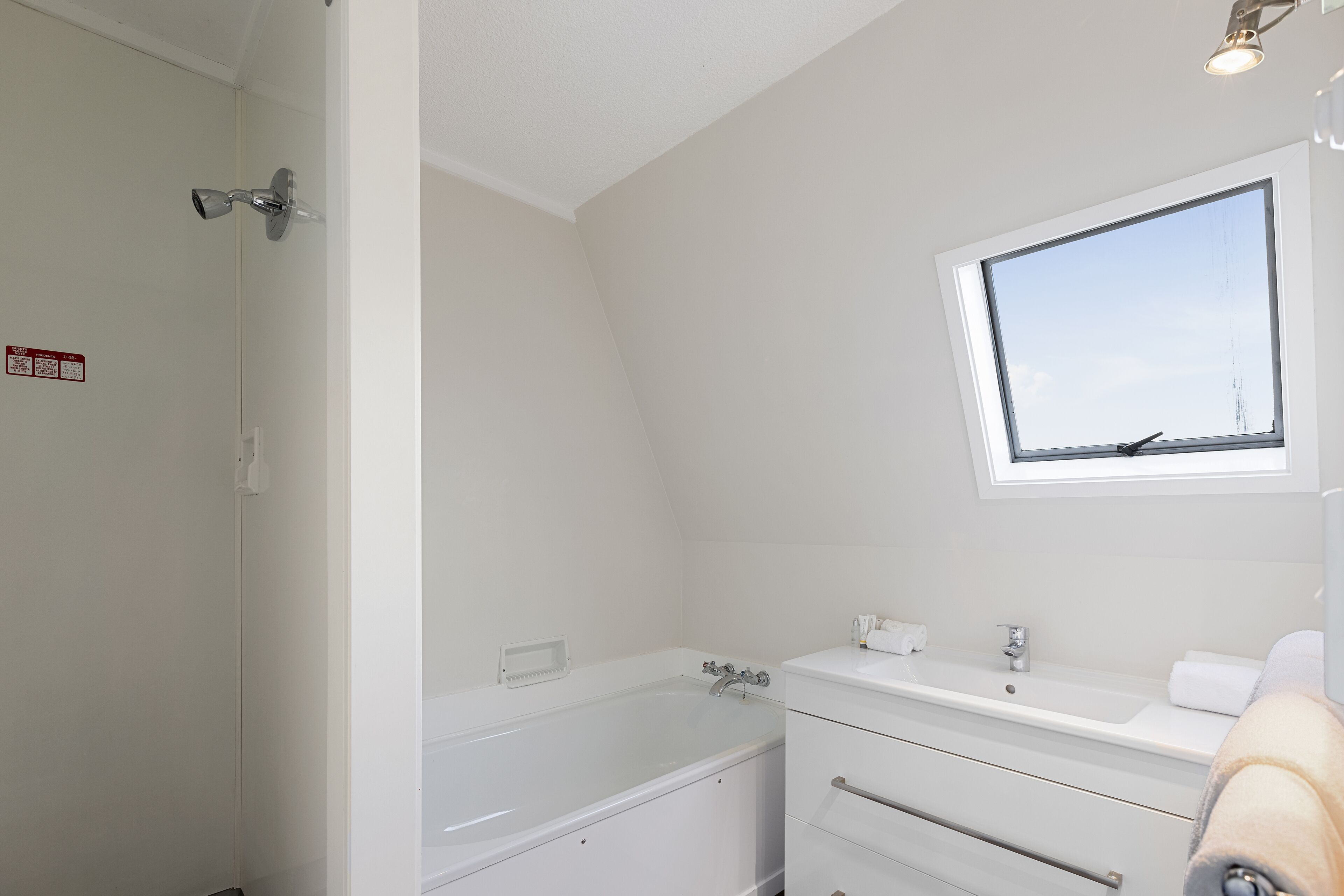 Un baño con bañera, lavamanos y ventana.