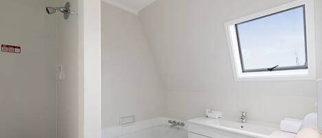 Un baño con bañera, lavamanos y ventana.