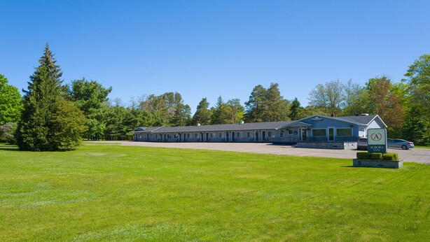 A motel with a large parking lot and a sign indicating it is an Aurora property.