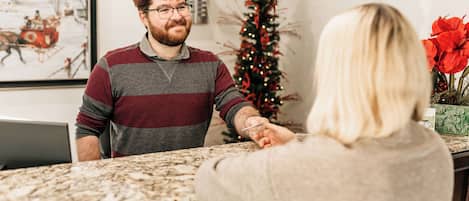 A reception area with a marble counter, a framed picture on the wall, and a Christmas tree.